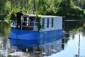 Atle Kultalahti pääsi laskemaan rakkaan veneensä vesille vuosikymmenten jälkeen. Veneen uppouma on vain 50 senttiä, mikä tarkoittaa, että se ui matalassa vedessäkin. Kuvassa Atle Kultalahden poika. Kuva: Hannu Takala