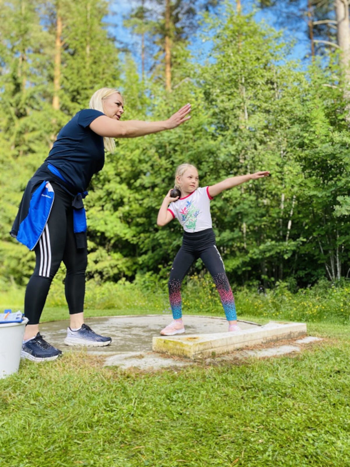 Vapaaehtoiset ohjaajat neuvovat ja kannustavat tarvittaessa suorituksissa. Johanna Kujala ohjaa nuorta kuulantyöntäjää ennen suoritusta.