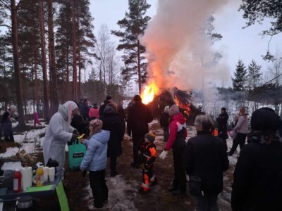 Porukkaa ihailemassa kokkoa ja pääsiäispupu töissään jakamassa palkintoja lapsille.