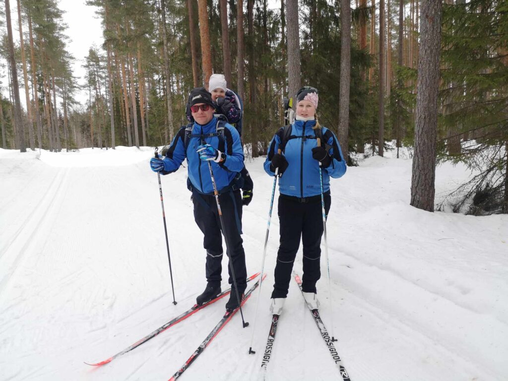 Ladulla tuli vastaan myös latumestari toisessa polvessa. Viivin matkaa helpotettiin hieman reppuselkäkyydillä. Kuvassa Mira Karvonen (oik.) ja Mikko Hautamäki repussaan Viivi Hautamäki. Heidän mielestään tapahtuma on oikein mukava. Viivi kertoi, että mumma on aina käynyt täällä.