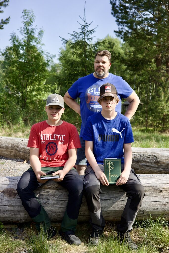 Ari Siltanen oli yksi eräkerhon alkuunpanijoista. Hän myös palkitsi viimeisessä kerhossa paikalla olleet Antti Talvitien (vas.) sekä Turo Söderlingin, jotka tenttivät ja läpäisivät eräkerhossa metsästyskortin itselleen. Kolmas kortin tenttinyt nuori Elias Mäkinen, ei päässyt viimeiseen kerhoon paikalle.