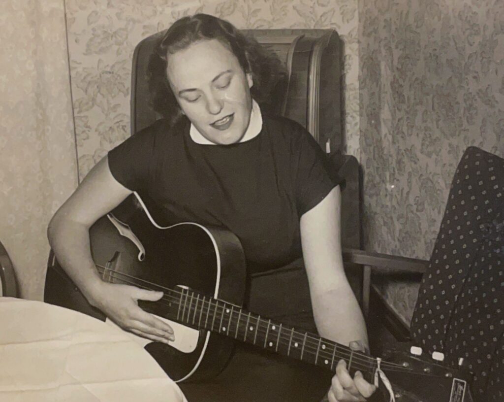 Kitaraa soittava Kaisu vuonna 1953, hänen ollessaan töissä tekstiilitehtaalla Boråsissa, Ruotsissa. Kuva: Kaisun kotialbumista.