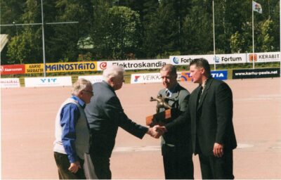 Valokuva tapahtumasta, kun Vimpelin Veto sai Vimpeli-palkinnon vuonna 2004. Vasemmalla palkinnon antajat: Lasse Saharinen Liikenneturvasta ja raadin pj. Matti Lehto. Oikealla vastaanottajat: Vedon pj. Tuomo Hovila ja Riku Lehto.