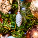 Beautiful closeup of a white ornament and other decorations on a Christmas tree with lights