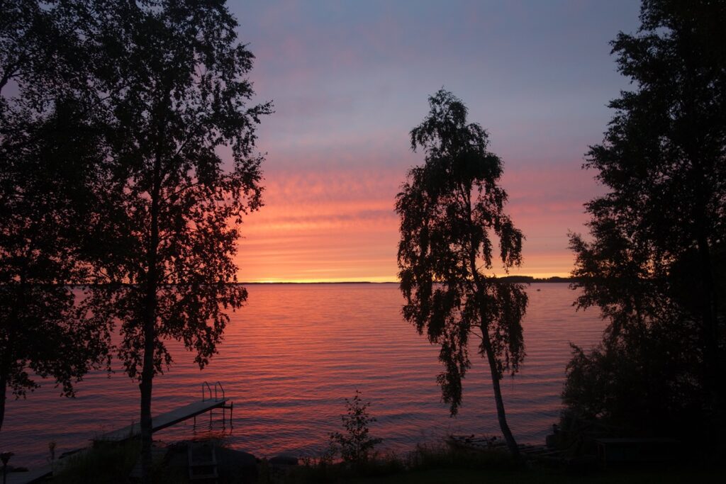 Eläkeukko nauttii auringonlaskusta hellepäivän jälkeen.