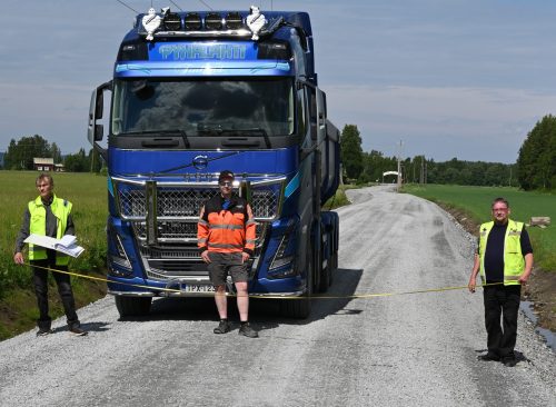 Asko Kuoppala ja Yrjö Koivukoski mittaavat valmistuneen tien leveyttä sen itäpäässä. Kuvassa keskellä urakoitsija Toni Pyhälahti. Kunnostetulla tieosuudella on pituutta 900 metriä.